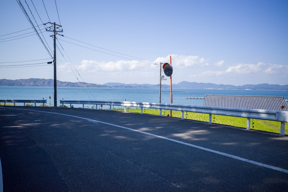 an empty road next to a body of water