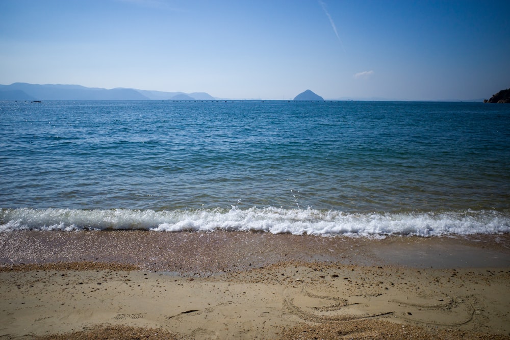 a body of water sitting next to a sandy beach