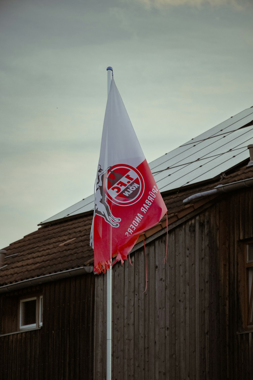 a red and white flag on top of a pole