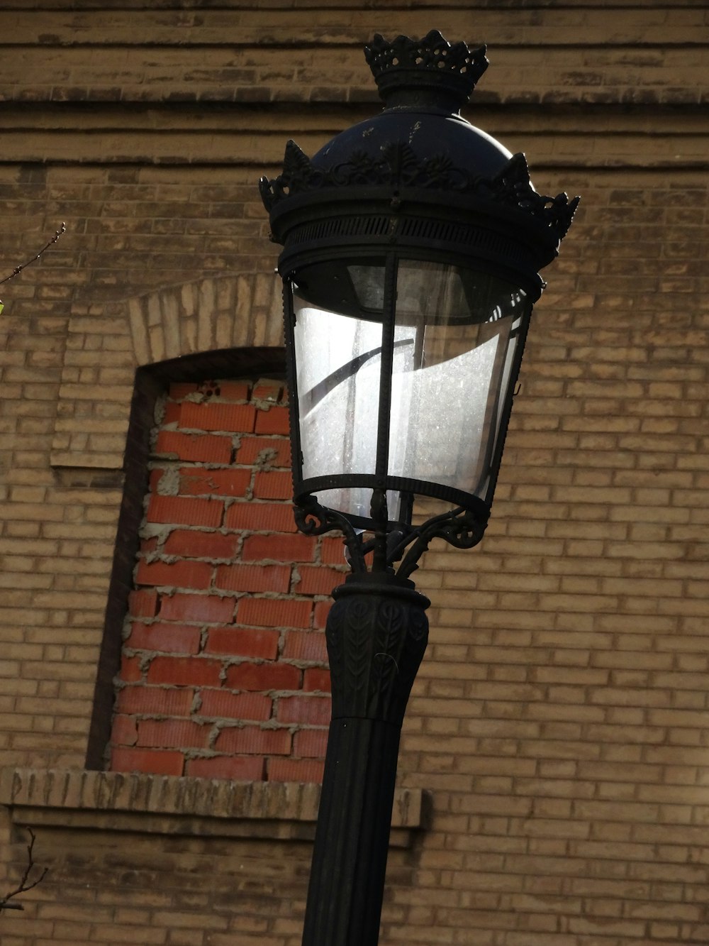 a lamp post with a brick building in the background