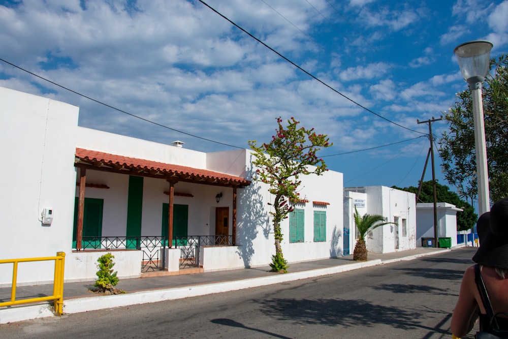 a person walking down a street next to a white building