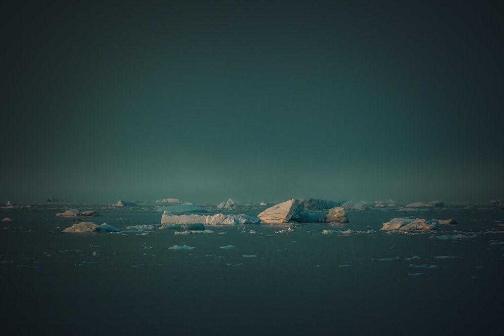 a group of icebergs floating on top of a body of water