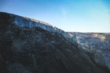 A glacial landscape with deep blue ice formations contrasting against a dark navy sky.
