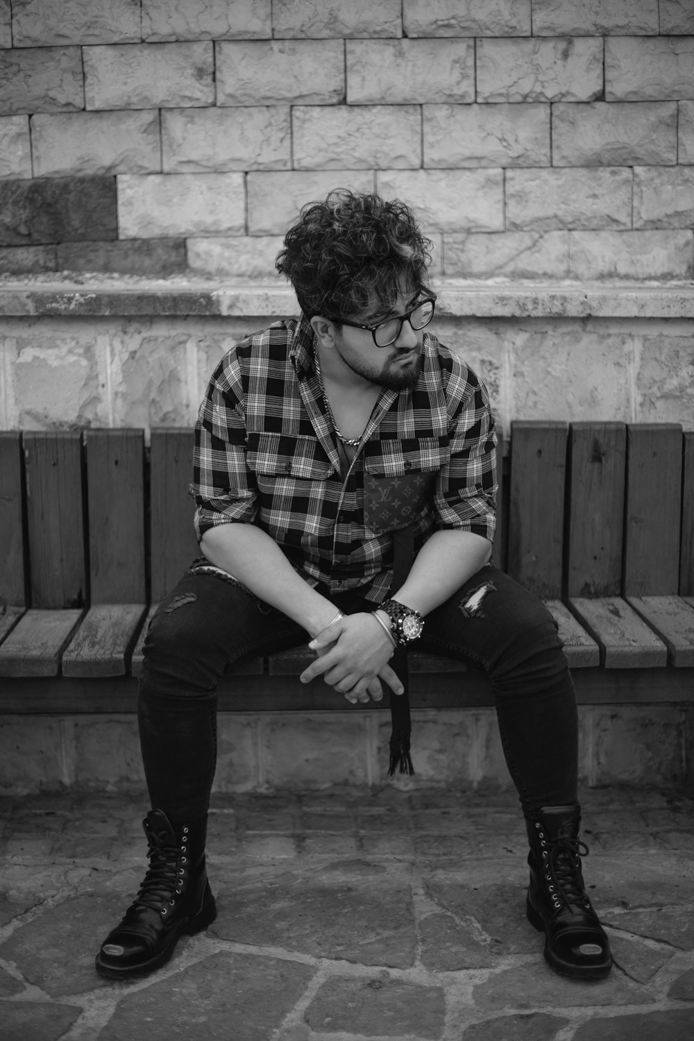 a man sitting on top of a wooden bench