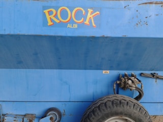 a blue trailer with a tire attached to it