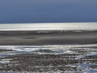 a person riding a horse on a beach near the ocean
