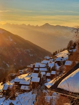 Cozy alpine apartment balcony overlooking Innsbruck with mountains in the background at sunset.