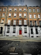 A cozy row of brick townhouses with flower boxes under bright morning light.