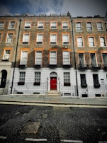 Historic brick townhouse with flower boxes on the windows.
