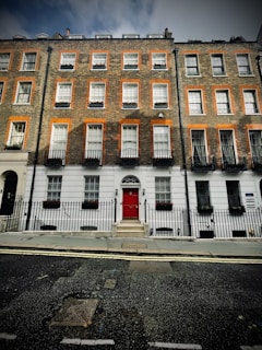 Historic brick townhouse with flower boxes on the windows.