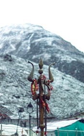 a statue of an elephant on a pole with a mountain in the background