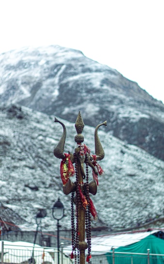 a statue of an elephant on a pole with a mountain in the background