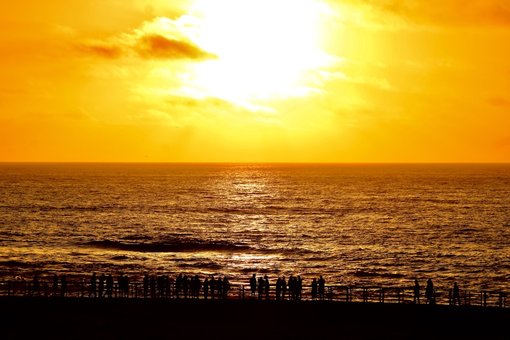 a large body of water with a sunset in the background