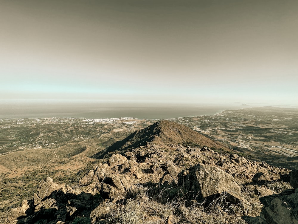 a view of a rocky mountain from the top of a hill