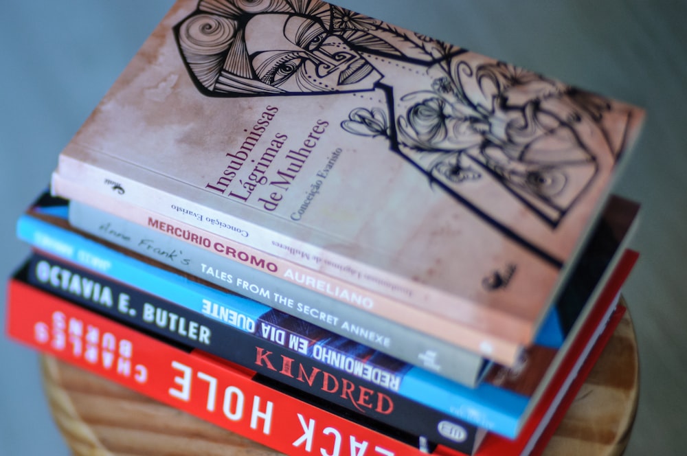 a stack of books sitting on top of a wooden table