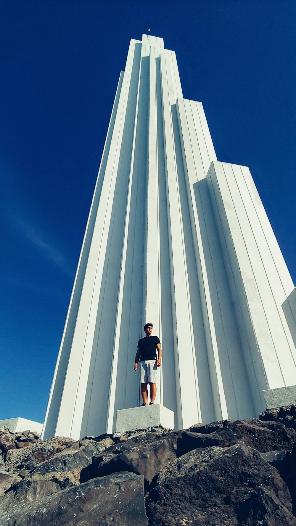 a man standing in front of a very tall building