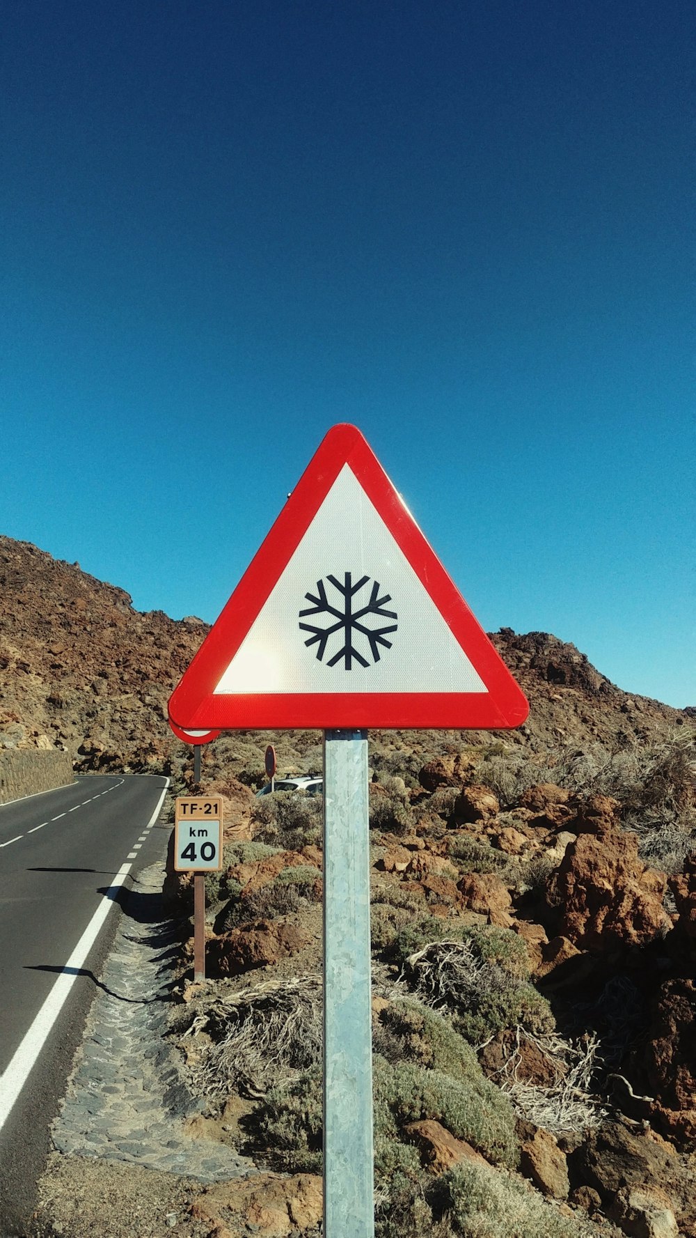 a red and white sign sitting on the side of a road