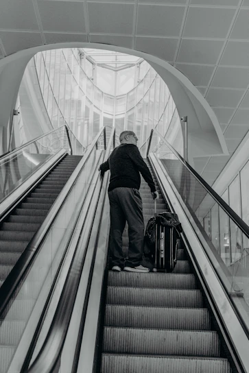 A stylish traveler looking at a luxurious hotel lobby with a suitcase.