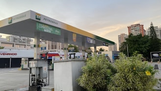 a gas station with trees and buildings in the background