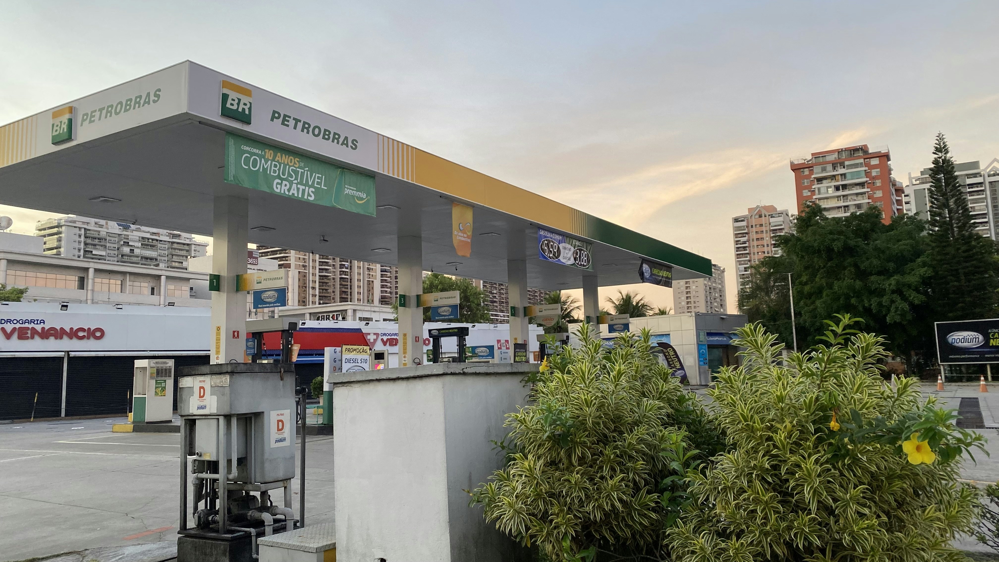 a gas station with trees and buildings in the background