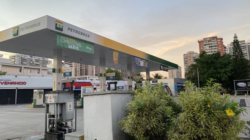 a gas station with trees and buildings in the background