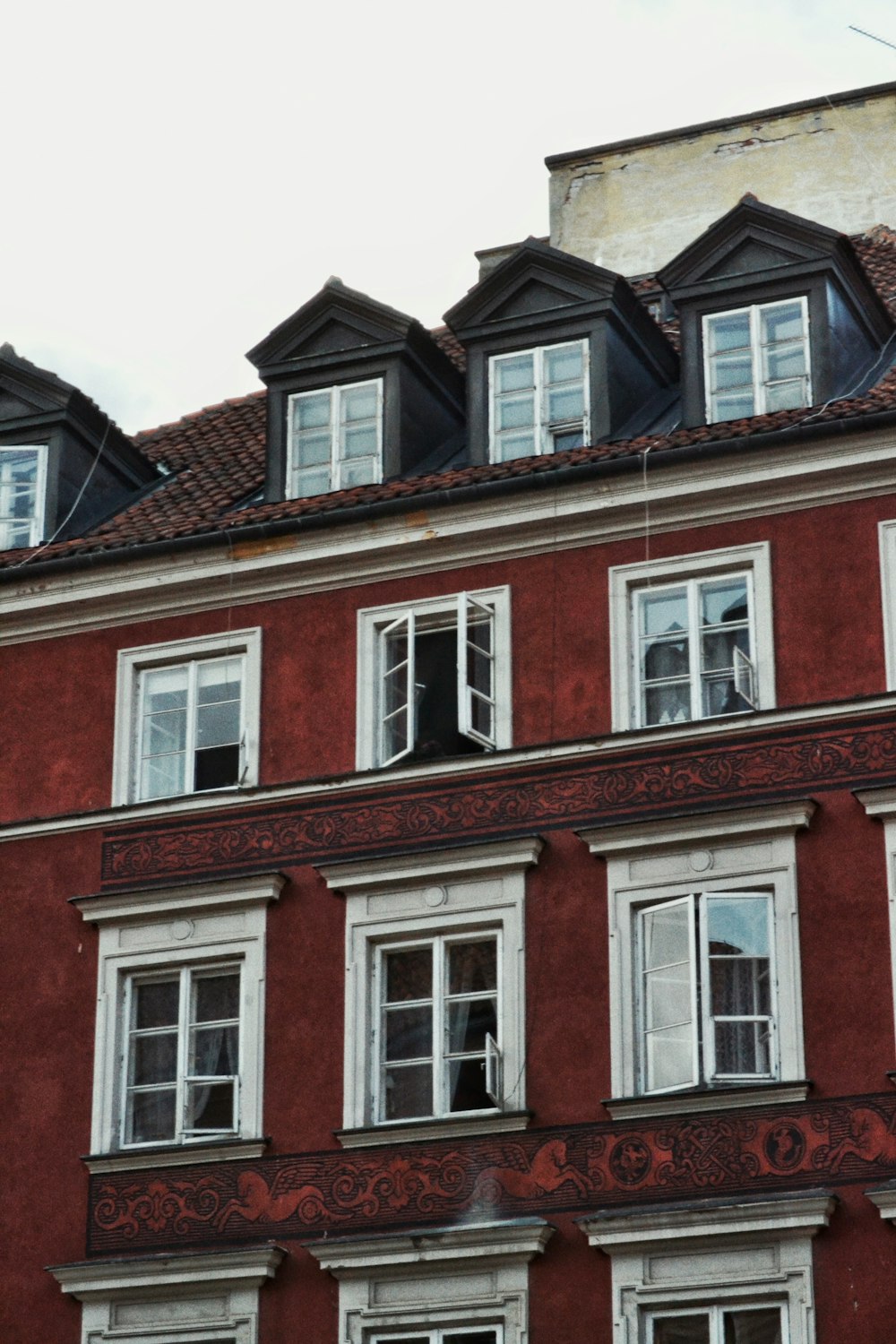 a red building with a clock on the front of it