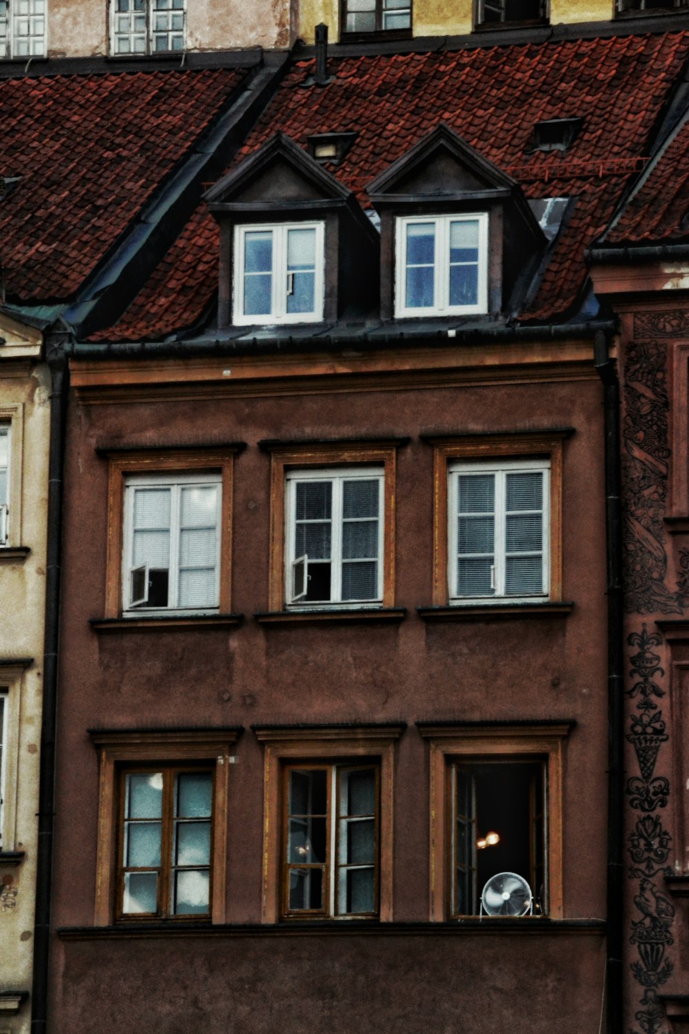 a tall brown building with a clock on it's side