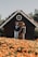 A happy couple standing in front of their new home, smiling and holding keys.