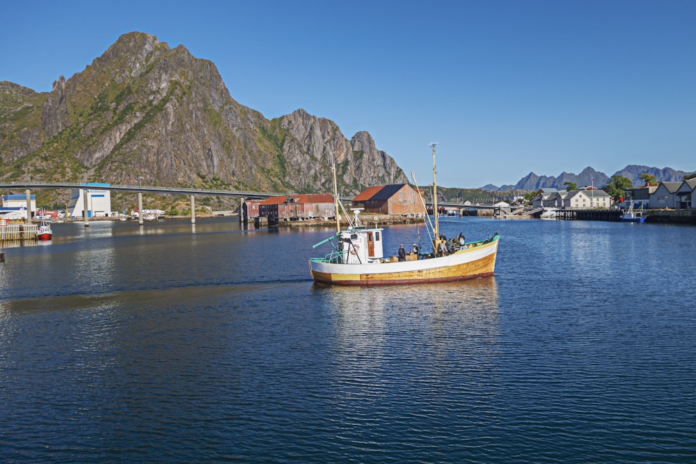 a small boat in a body of water with mountains in the background