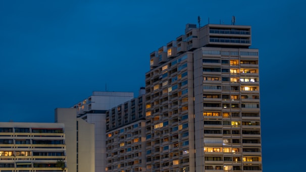 Evening view of a high-rise building with newly installed exterior envelope lit by city lights.