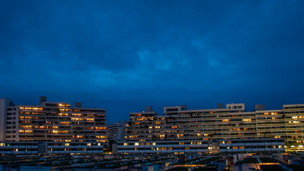 Modern real estate buildings illuminated against a dark sky, highlighting investment potential.