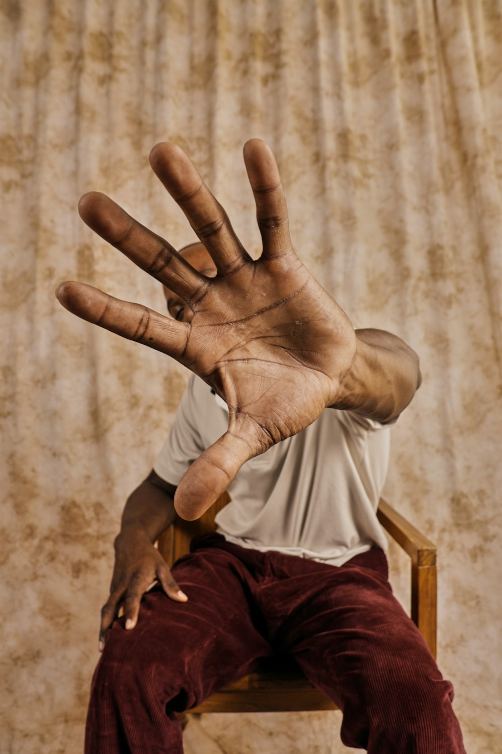 a man sitting in a chair with his hand up