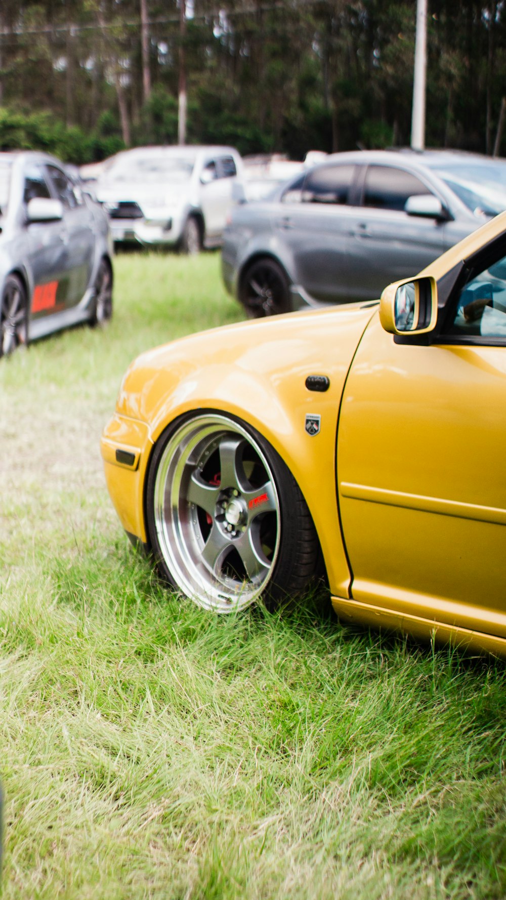 a yellow car parked in a grassy field