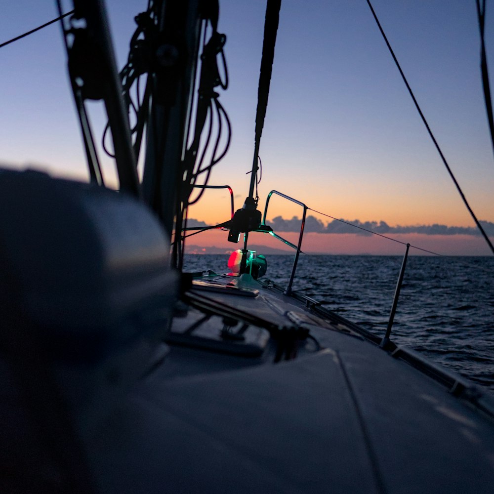 a view of the back end of a sailboat at sunset