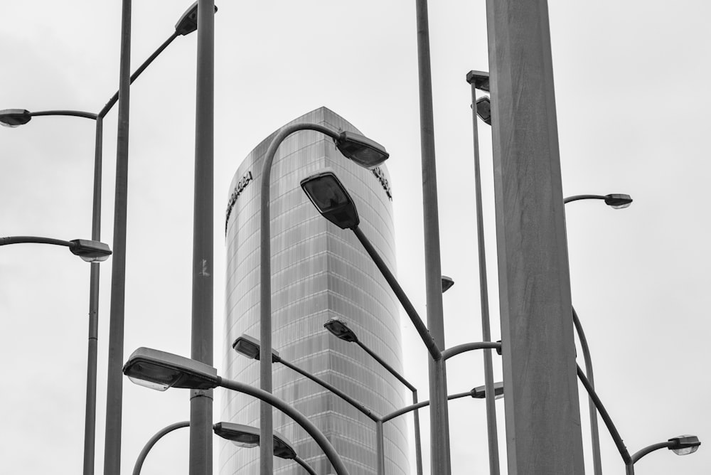 black and white photograph of street lights and a skyscraper
