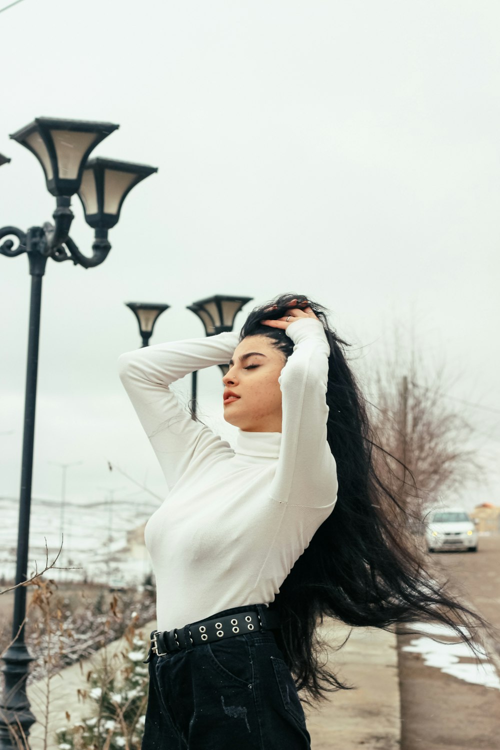 a woman standing next to a street light