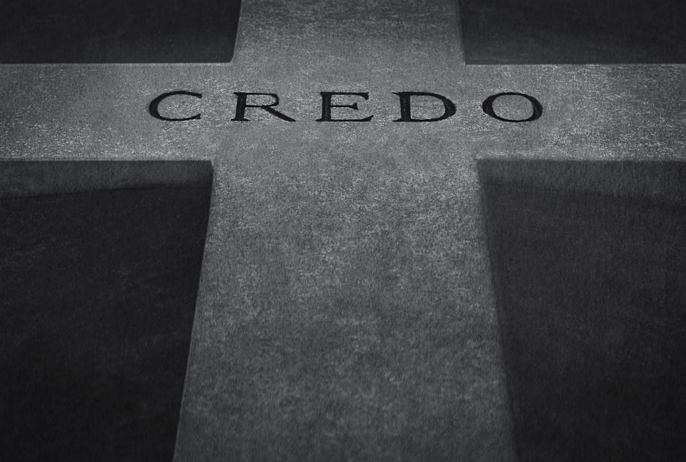 a black and white photo of a cross with the word credo on it