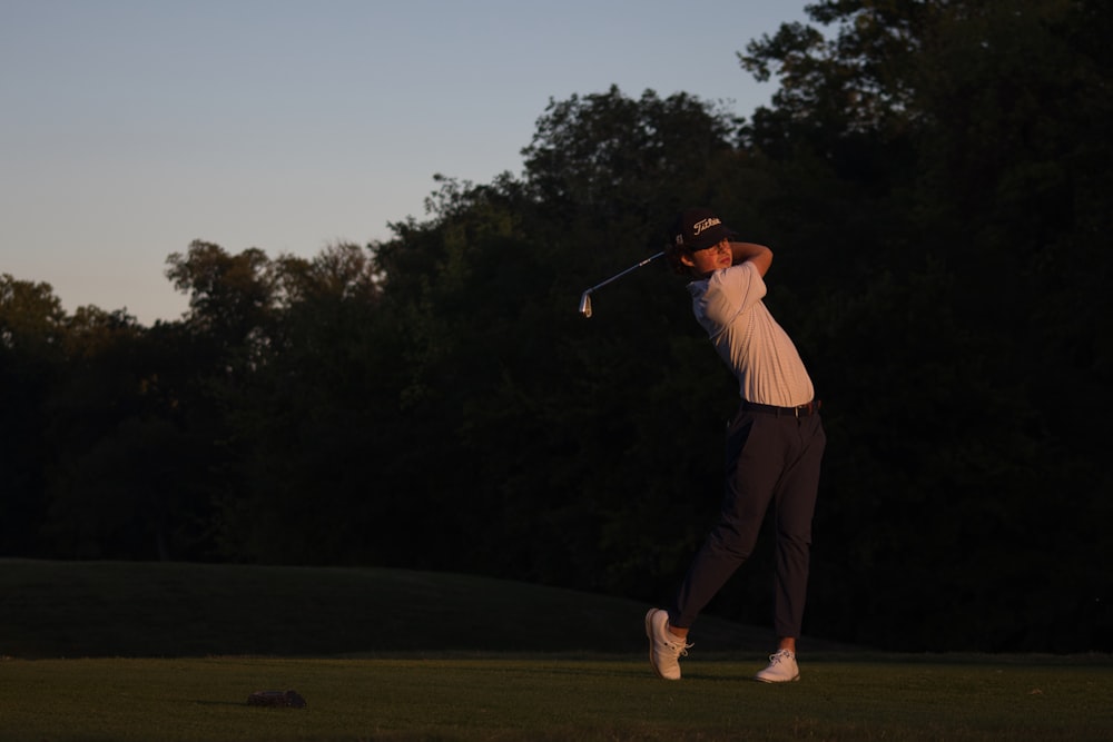 a man swinging a golf club on a golf course