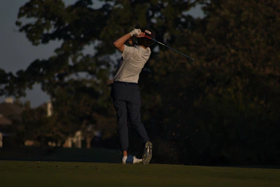 Pro signature trousers displayed on a golfer mid-swing with adjustable waistband and tee holder visible