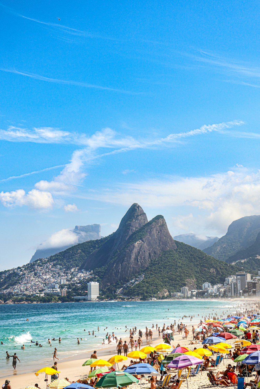 a crowded beach with many people and umbrellas