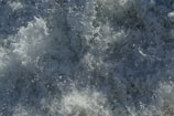 Chaotic and dynamic splashes of water with white foam forming intricate patterns as waves crash.
