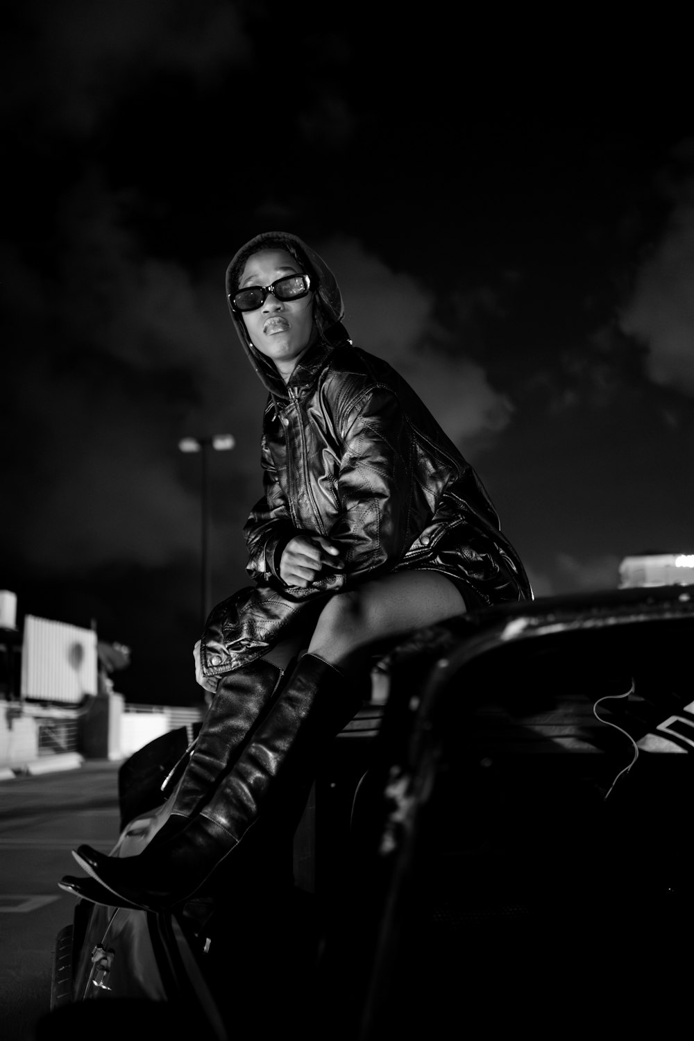 a woman sitting on the hood of a car