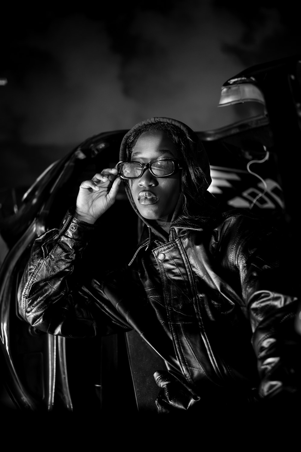 a black and white photo of a woman in a leather jacket