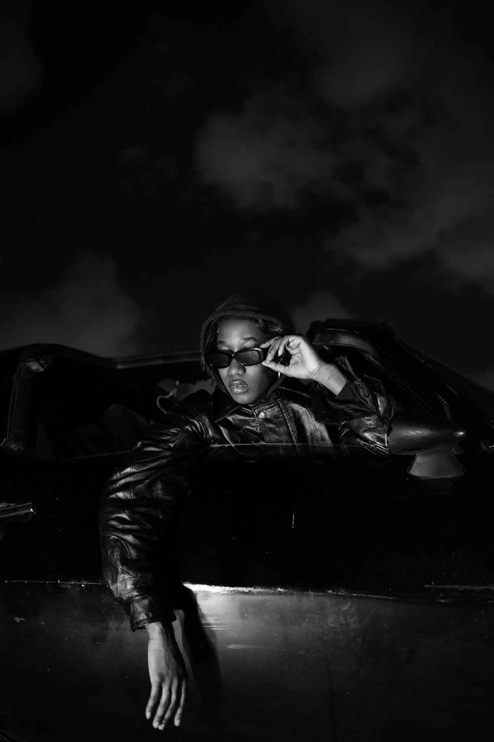 a man sitting in the back of a car talking on a cell phone