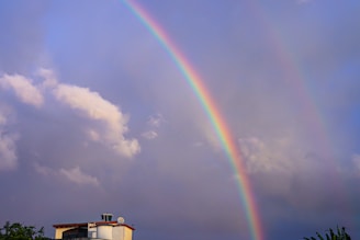 a double rainbow in the sky over a house