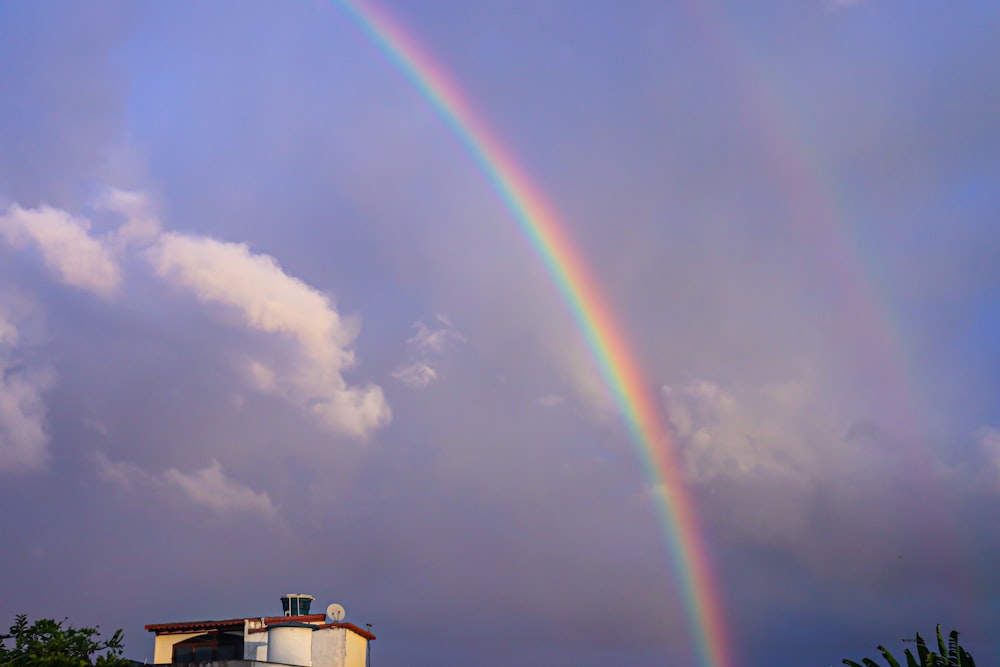 家の上の空に浮かぶ二重の虹