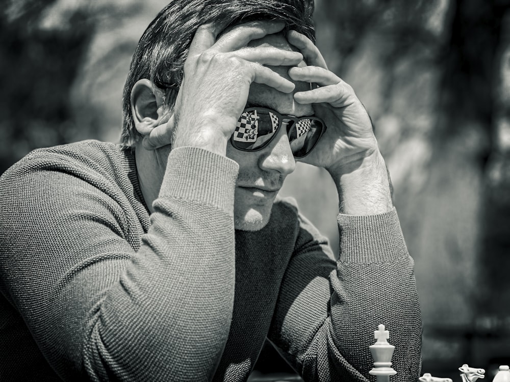 a man sitting at a table with a chess board