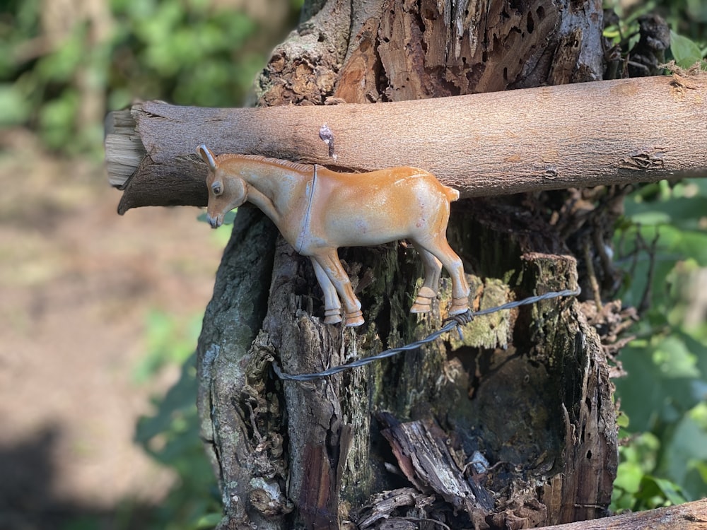 a toy horse on a wire next to a tree