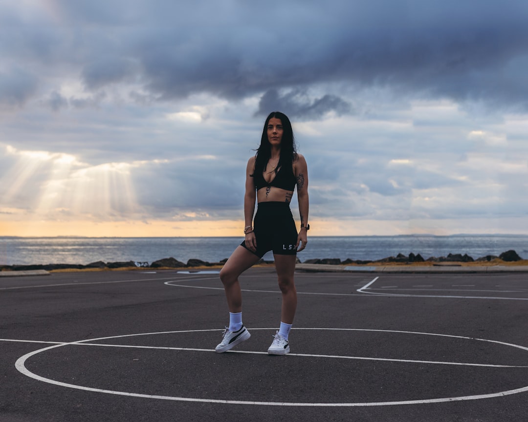 a woman standing on a basketball court holding a tennis racquet,