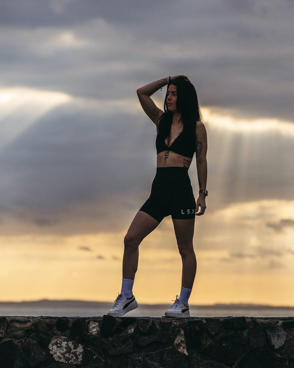 a woman standing on top of a rock wall